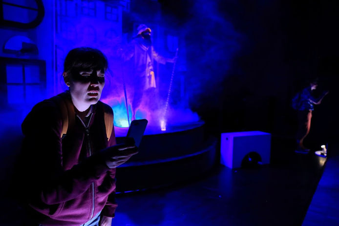 One actor looking down at a phone.