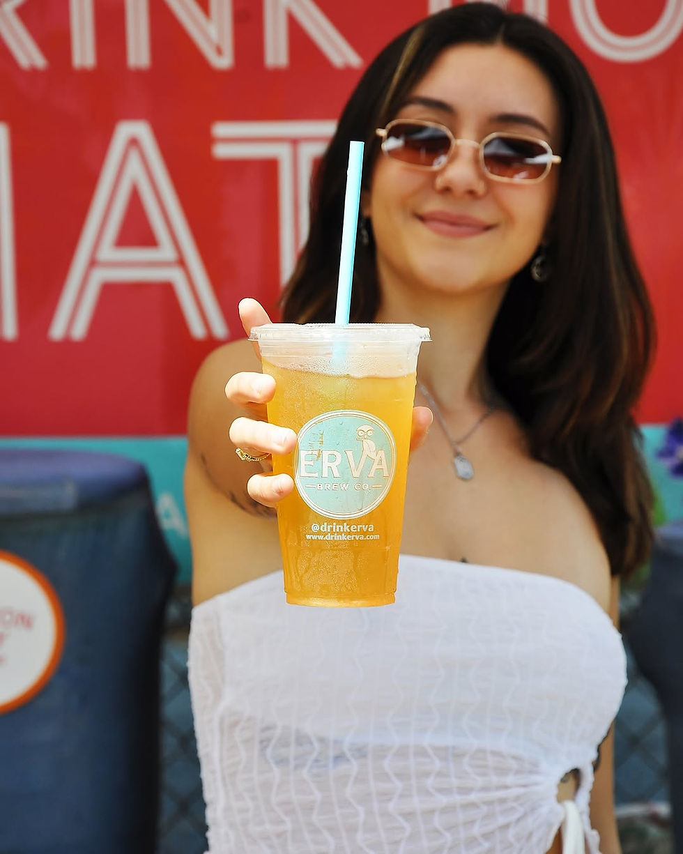 A girl wearing glasses holding up an Erva Brew chilled organic blend.