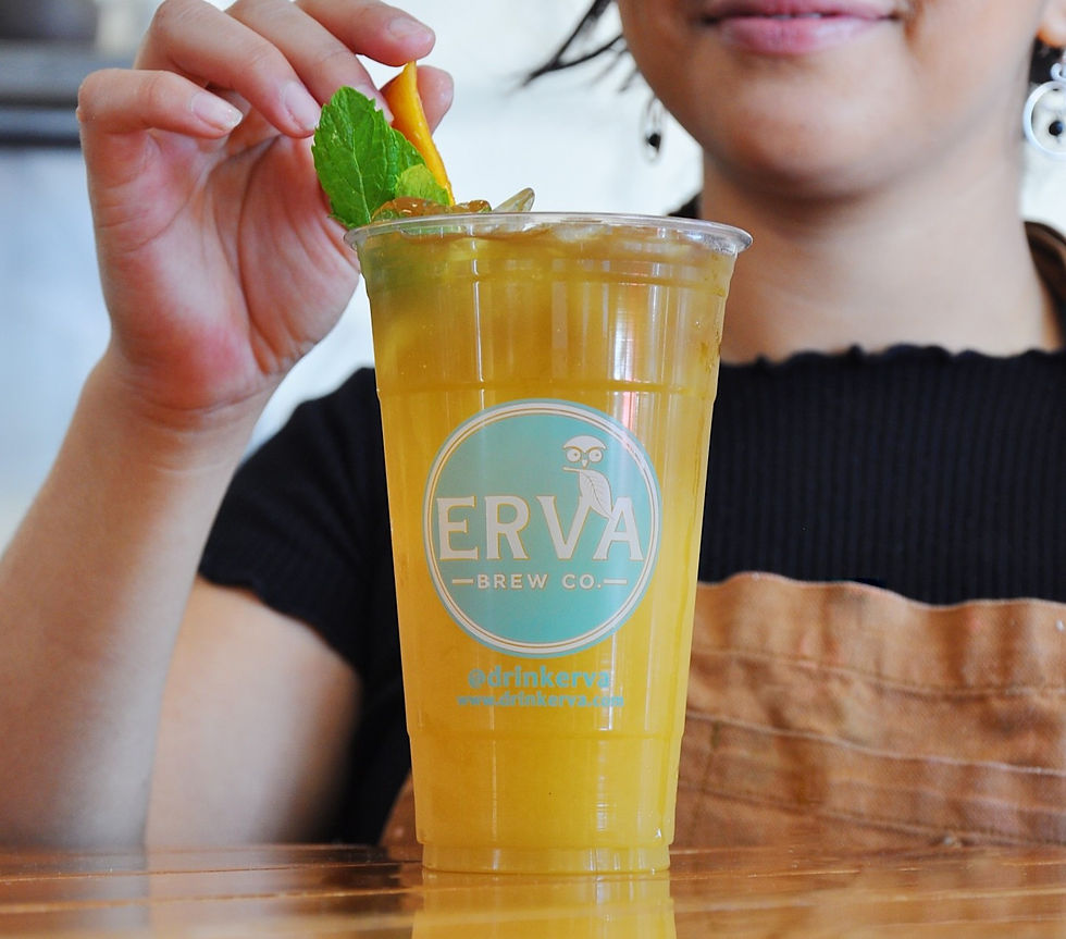 A woman serving Erva Brew’s yerba mate drink with mint garnishing.