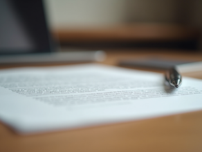 Eye-level view of a legal document with a pen on a wooden desk