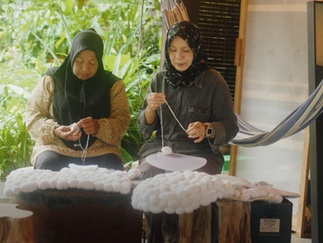 Two women handcrafting yarn