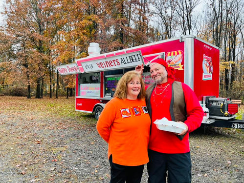 Man in red hat and woman by food truck
