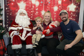 Santa Claus with a family of four, including a baby