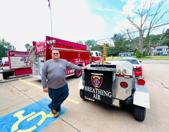 Firefighter with mobile breathing air unit