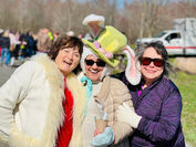 Three smiling women at an event, one wearing an Easter Bunny hat.