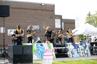 a full band on stage at an outdoor festival