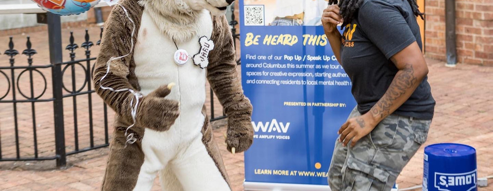Ebri and someone in an animal costume dancing at Pop-Up / Speak-Up