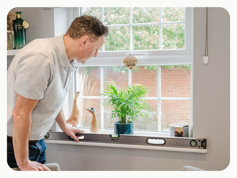 Surveyor using a spirit level to check the alignment of a window during a new-build snagging inspection.