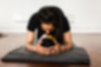 Postnatal woman practicing postnatal yoga with her baby.