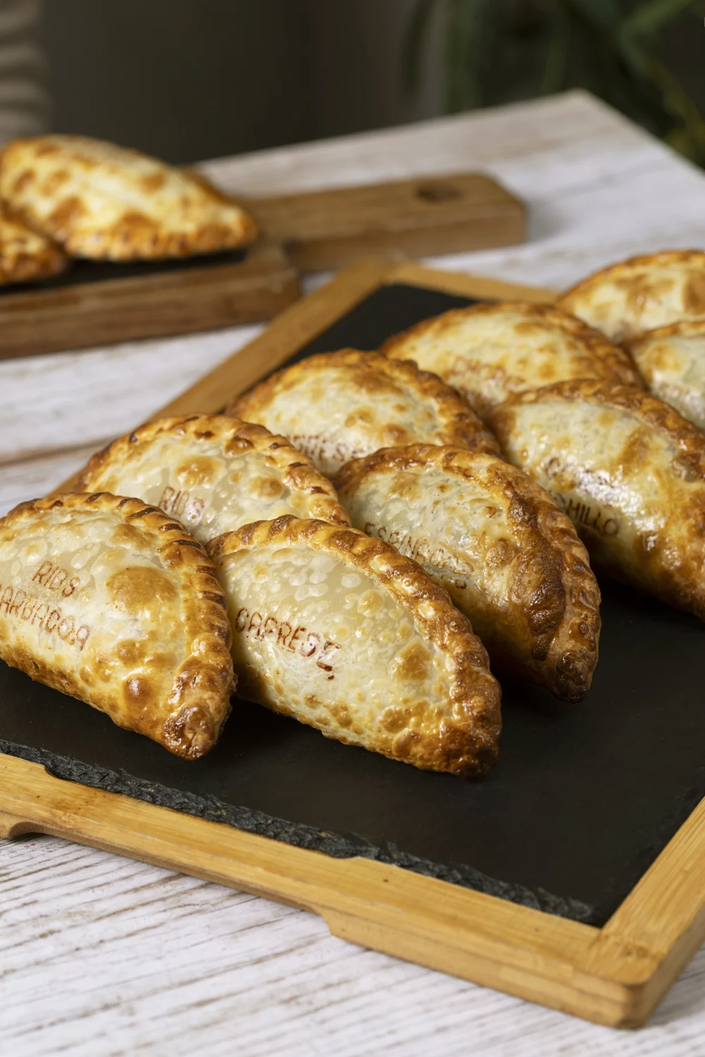 Empanadas dorées disposées sur un plateau en bois