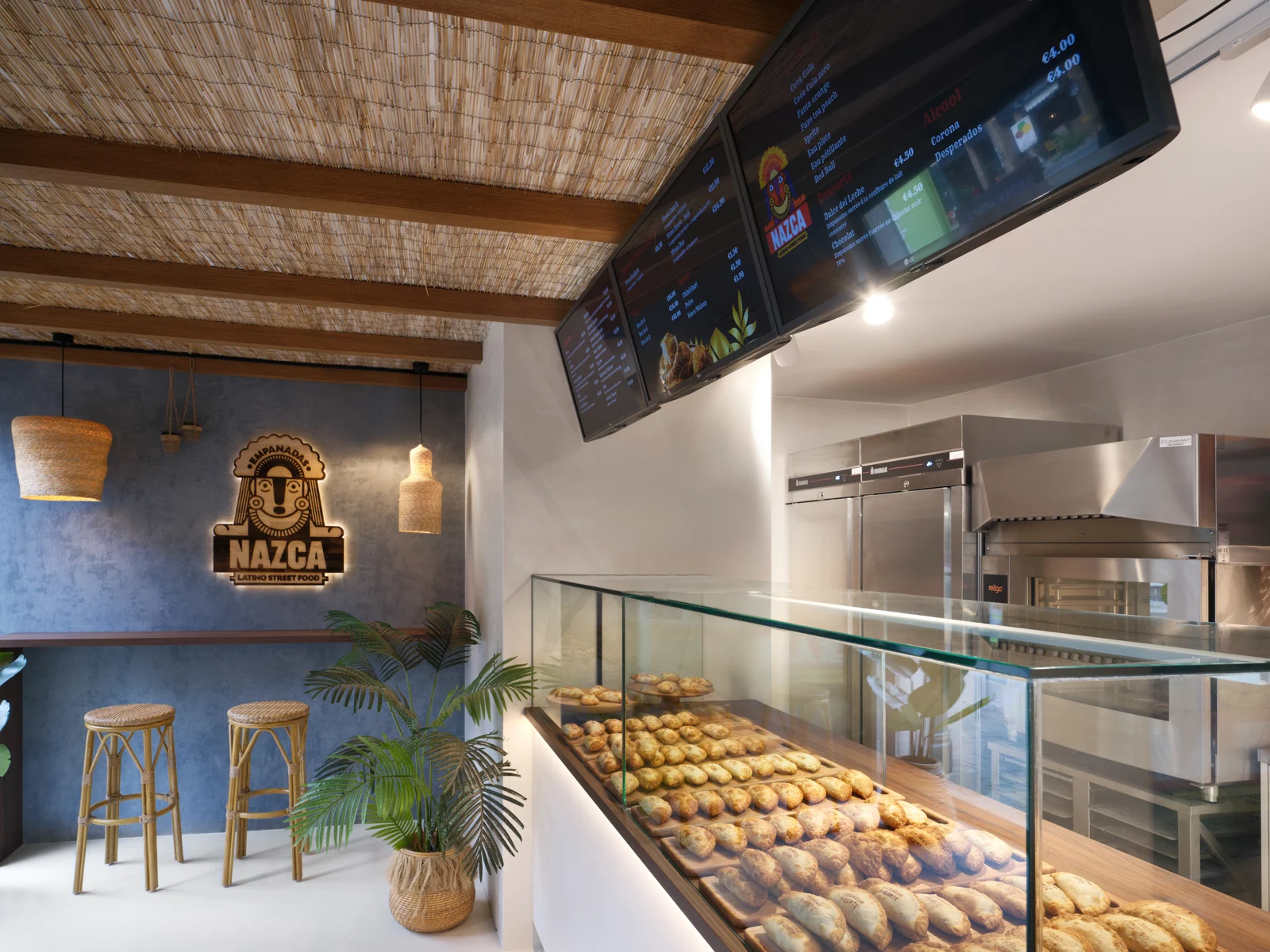 Intérieur d’un magasin Nazca : comptoir d’empanadas, bois et logo mural
