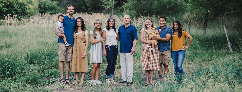 family of 10 posing in a field with tree background