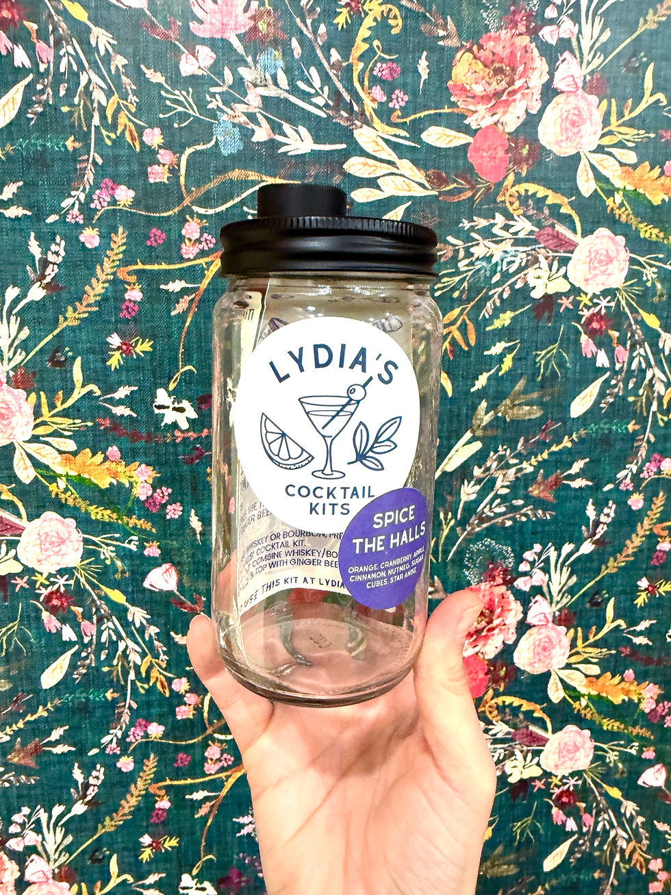 Hand holding glass jar with 'Lydia's Cocktail Kits' label