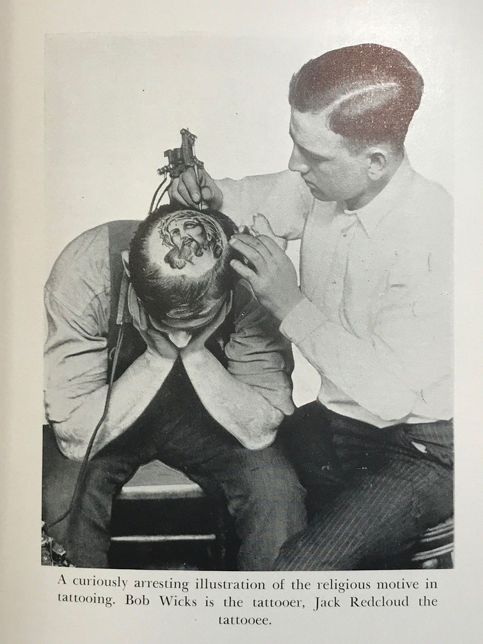 A curiously arresting illustration of the religious motive in tattooing. Bob Wicks is the tattooer, Jack Redcloud the tattooee.
