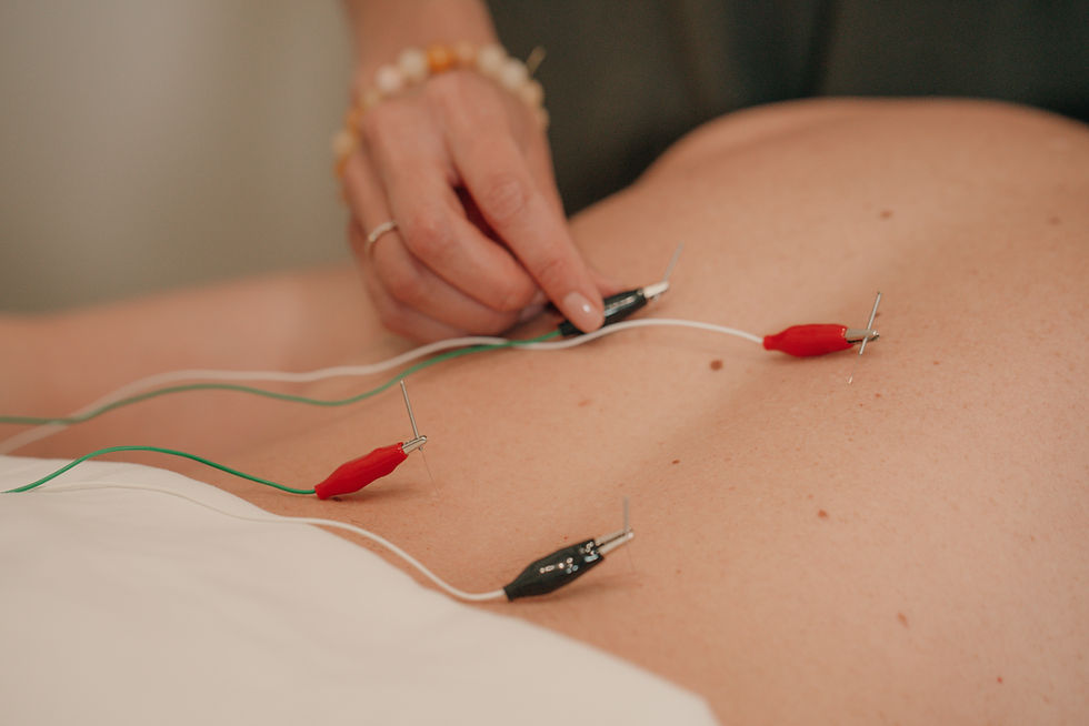 Eye-level view of a small travel pouch with dried herbs and acupuncture tools on a wooden table