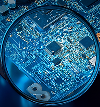 Close-up of microchips and circuits on a PCB under magnifying glass during electronic inspection