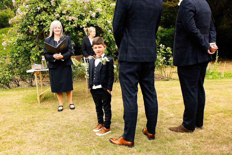 boy stands beside the groom awaiting the bride
