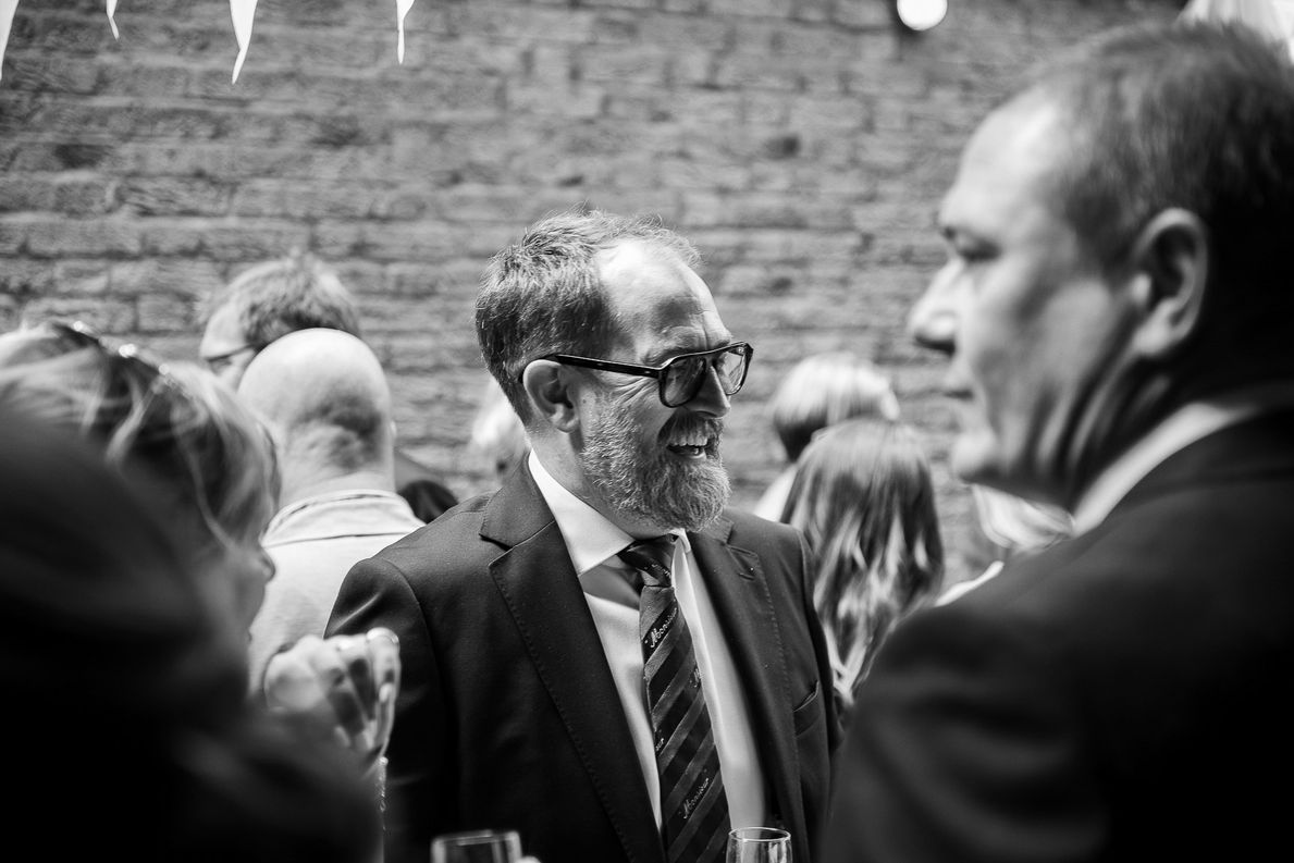 Man in suit smiles at wedding reception