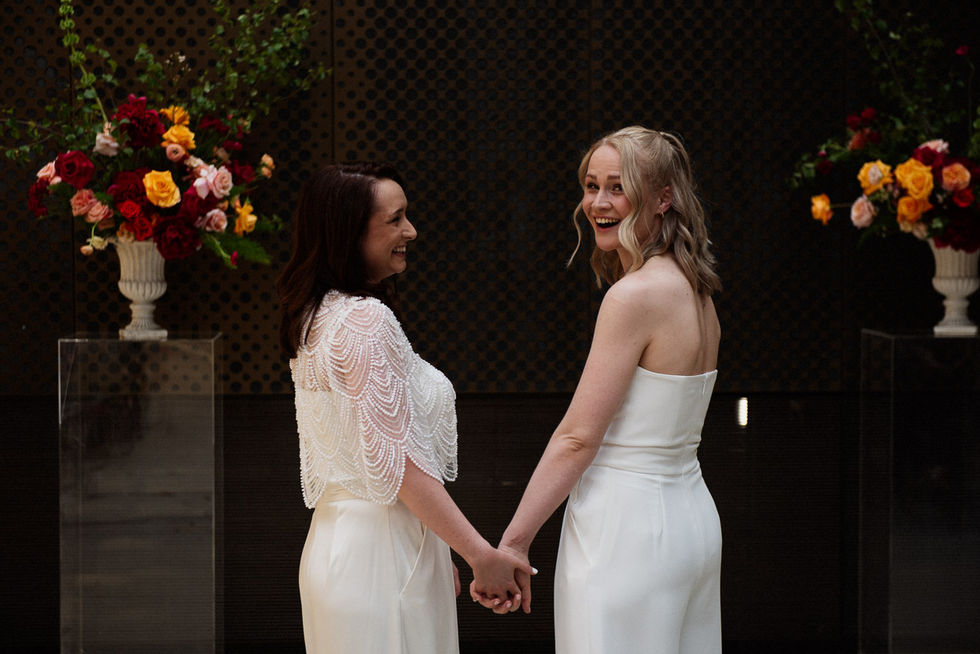 Happy lesbian couple holding hands, wedding ceremony