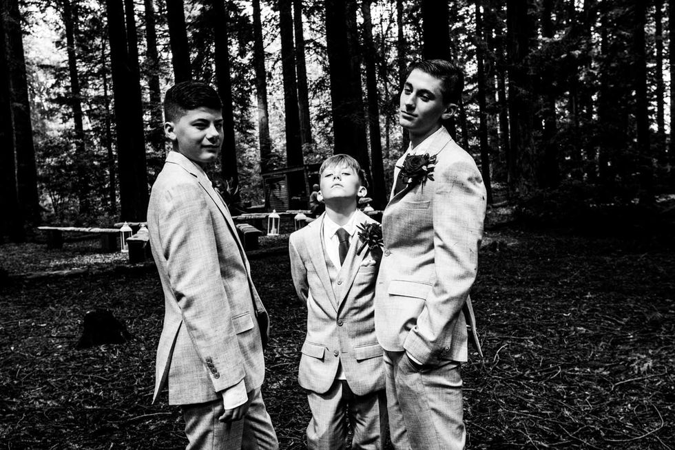 Three groomsmen in suits, woodland wedding photo