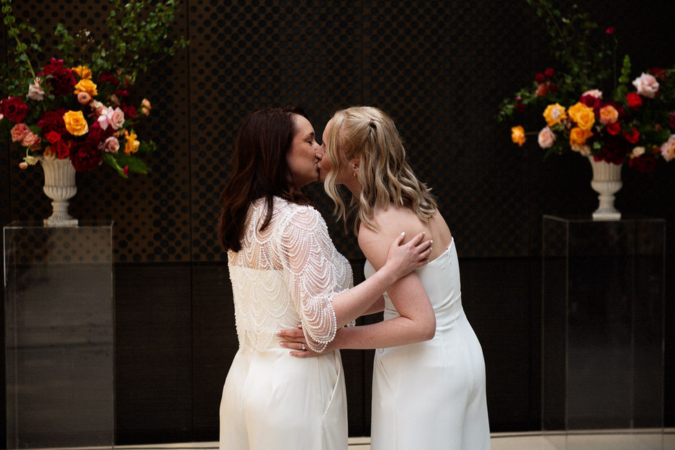 Bride kissing bride at wedding ceremony