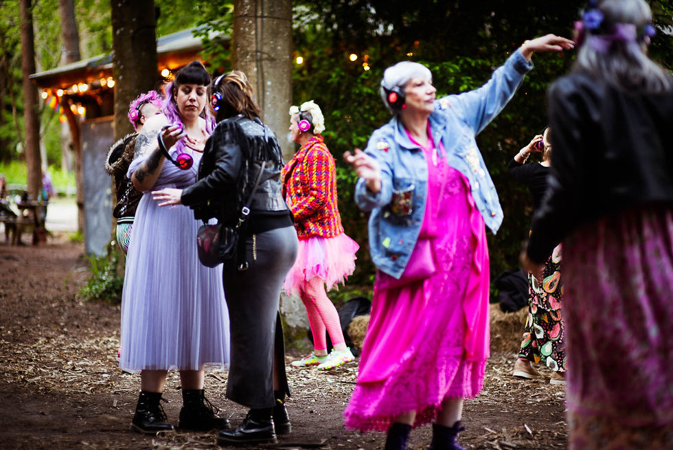 Eclectic wedding guests dancing at an outdoor forest silent disco celebration at Wilderness Wood East Sussex by Craig Preston Roberts