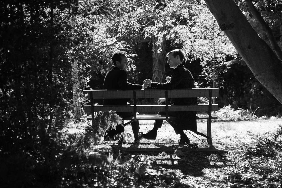 Couple holding hands on park bench