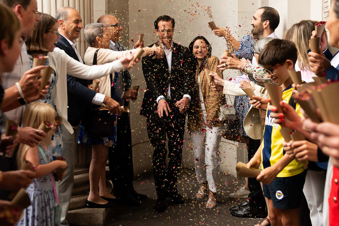 newlyweds walk through confetti laughing