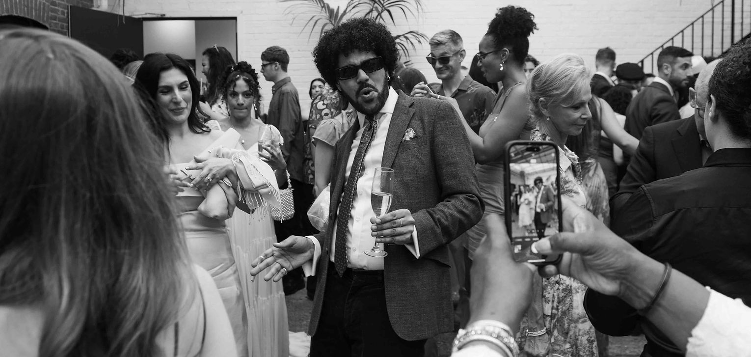 Black and white documentary wedding photography at Loft Studios London capturing guests chatting during a reception.