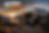 Luxury fifth-wheel toy hauler campsite overlooking a mountain lake at sunset with off-road UTV