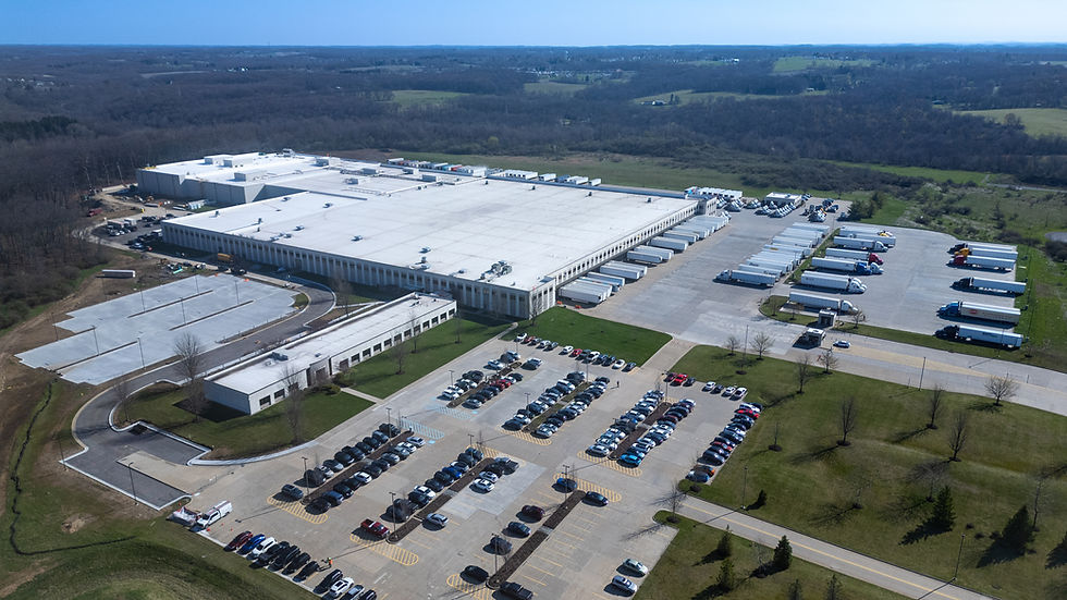 Commercial roofing contact form over an aerial view of a large low-slope roof project.