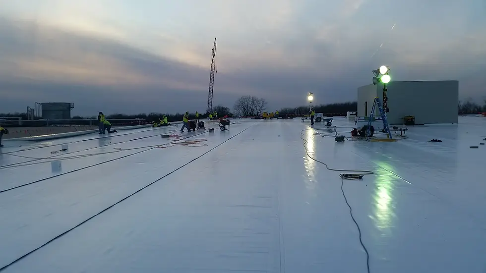 Schultheis Roofing crew installing a low-slope commercial roof on a large building.