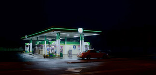 a service station glows in the foggy night