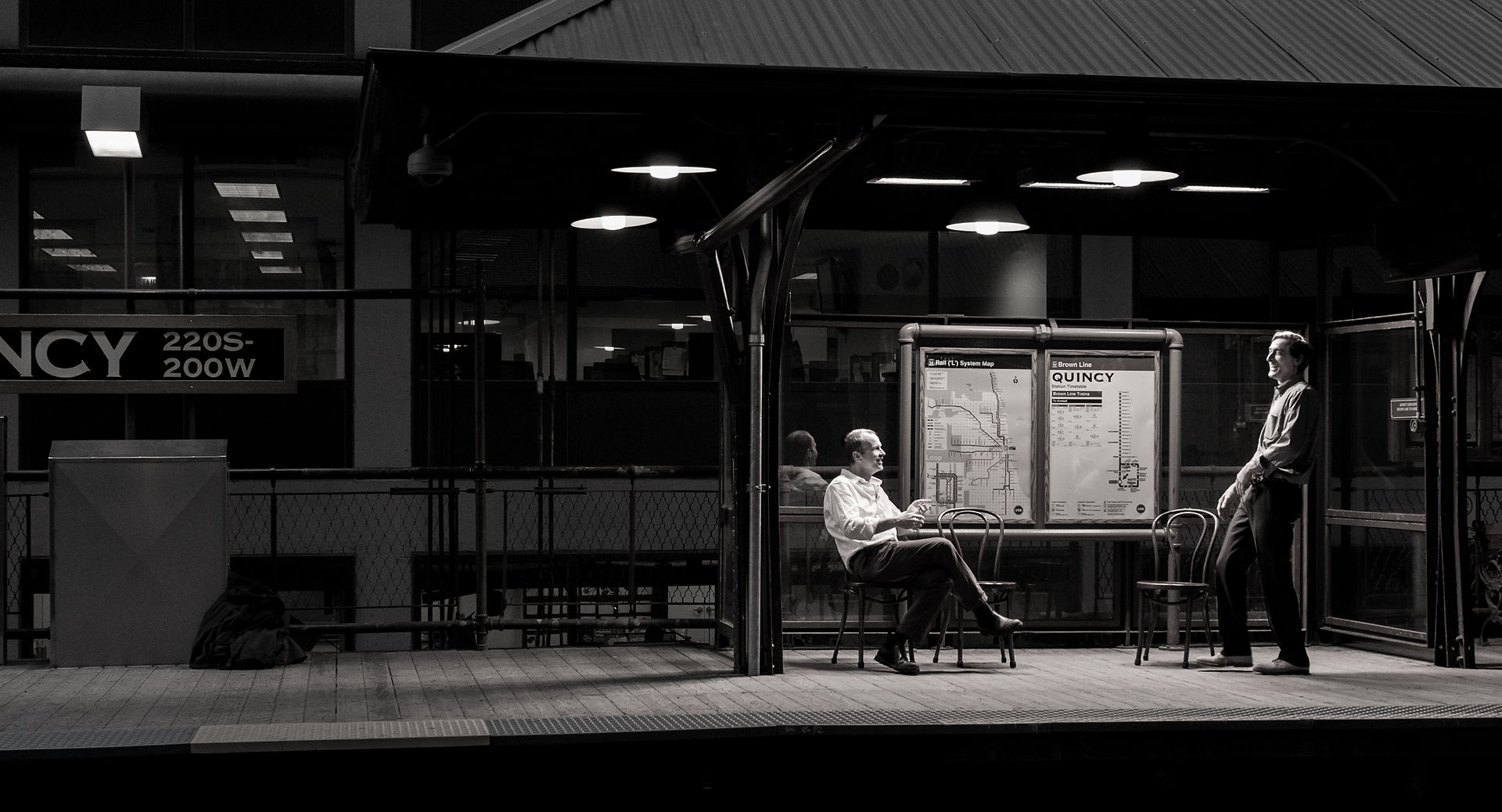 a black and white photograph of improvisation duo, TJ & Dave performing on the Quincy Street El platform in Chicago