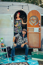 Rockabilly couple hanging out in doorway of vintage trailer