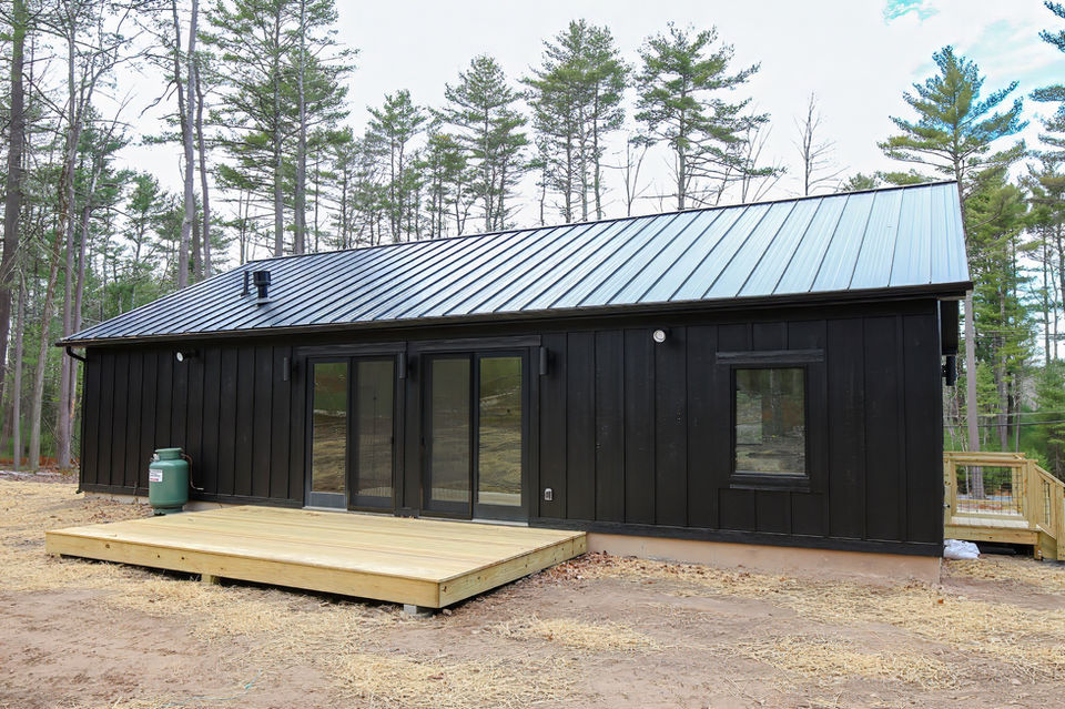 modern cabin dark and moody all black modern minimalist exterior deck patio.jpeg