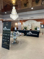 A formal presentation hall highlighting a large hanging crystal chandelier above display banners.A formal presentation hall highlighting a large hanging crystal chandelier above display banners.