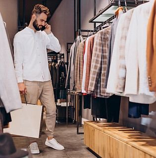 photo d'un homme qui regarde un portant  tenant un sac de shopping