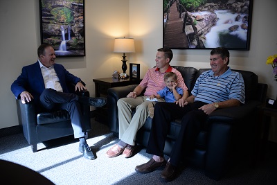 Three men and a child sitting in a comfortable office lounge