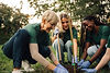 Diverse volunteers planting a young tree together.