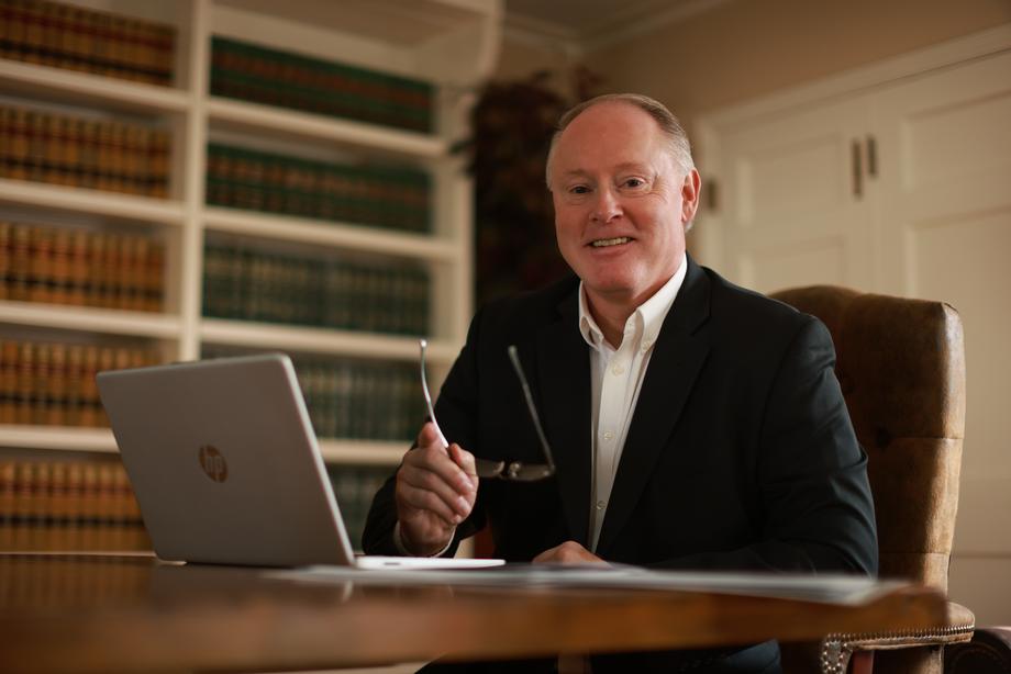 Professional man with laptop in a law library setting
