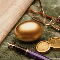 Golden egg with coins, glasses, and a fountain pen.