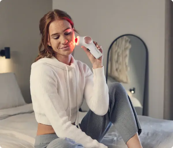 A woman enjoys a relaxing skincare routine using the Therabody Theraface Pro