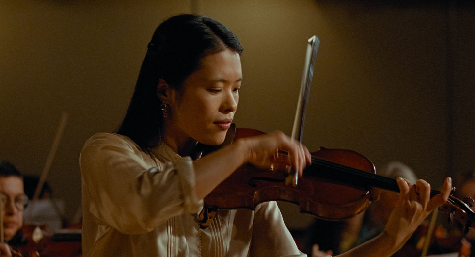 Still frame from the short film ‘Tremolo,’ featuring a woman playing the violin, immersed in the music.