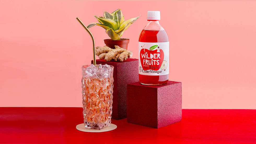 Berkshire Product Photography: A bottle of apple cider vinegar on a pedestal with a drink in decorat