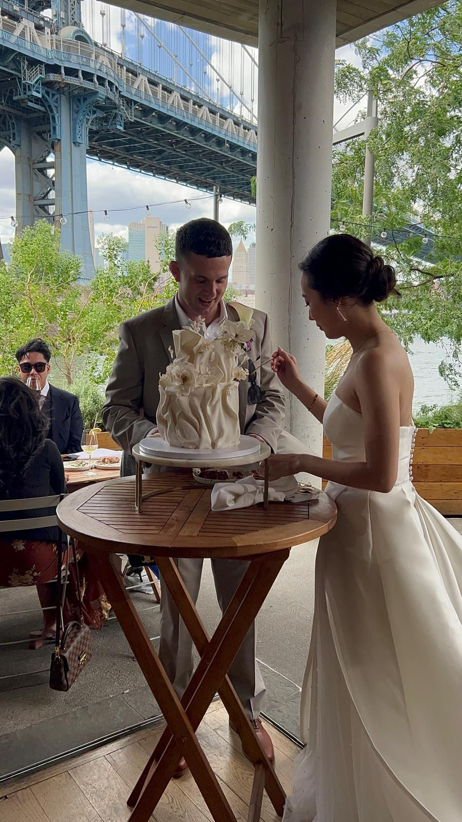 a bride and groom are cutting their wedding cake