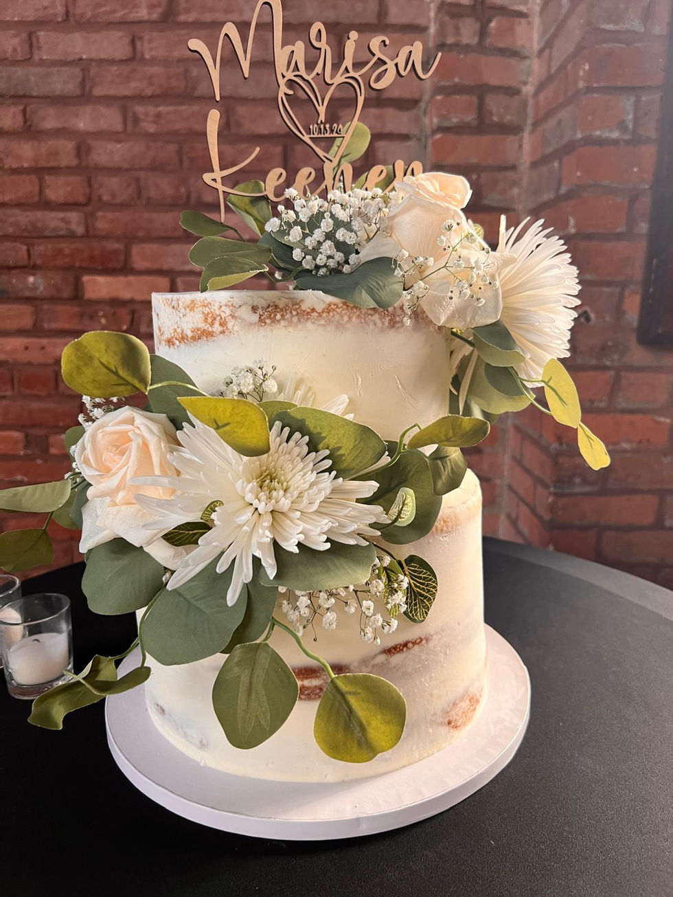 a cake with flowers and leaves on it and a topper that says leehen