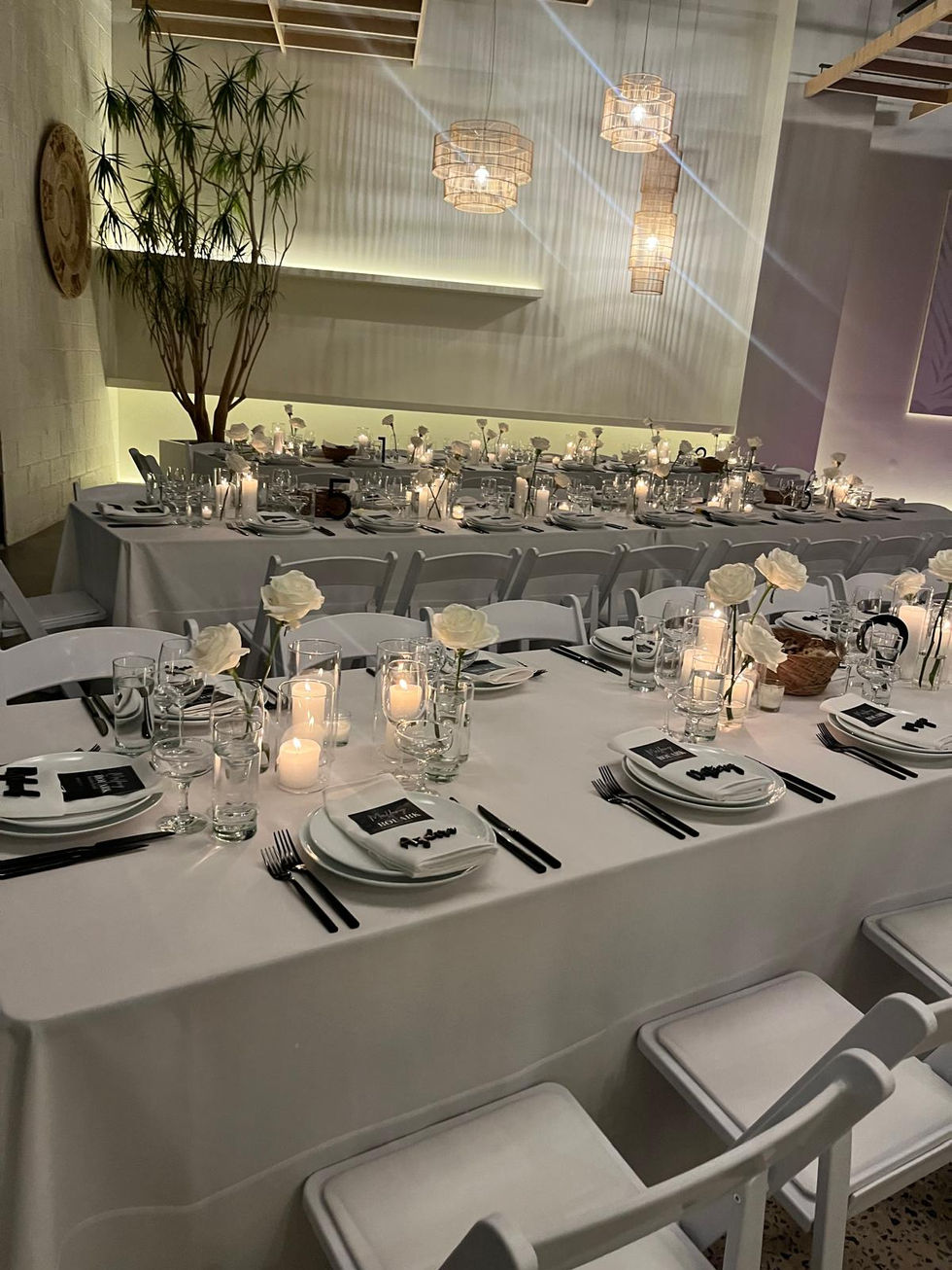 a table set for a wedding reception with plates and candles