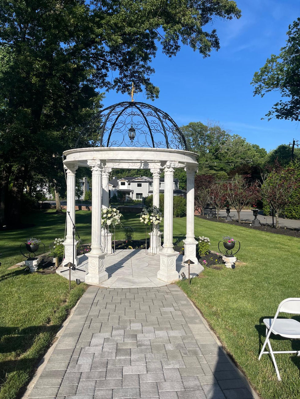 a gazebo with flowers and a bell on top of it