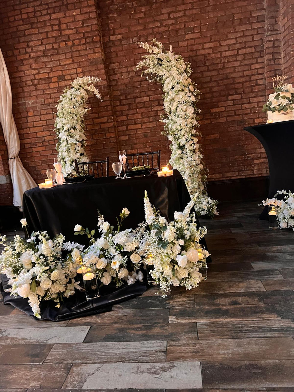 the bride and groom 's table is decorated with white flowers and candles